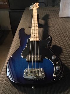 a blue bass guitar sitting on top of a table