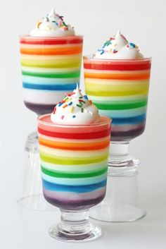 three glasses filled with rainbow colored desserts