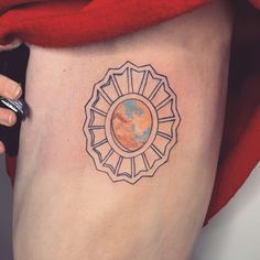 a woman's thigh with a tattoo on it that has the earth in a circle