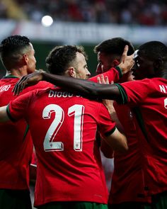 a group of soccer players standing next to each other with their arms around one another