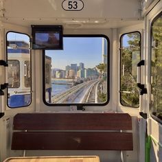 there is a bench on the side of the bus looking out at the water and buildings