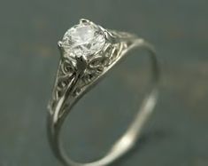 a white gold engagement ring with an old - fashioned design and a round diamond center