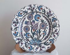 a white and blue plate with flowers on it