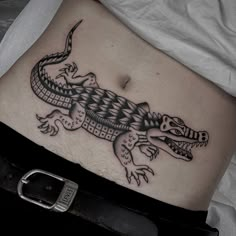 a lizard tattoo on the side of a woman's stomach