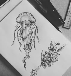 a drawing of a jellyfish and flowers on a piece of paper next to scissors