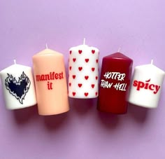 five candles with different designs on them sitting next to each other in front of a purple background