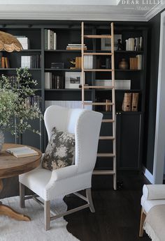 a living room filled with furniture and bookshelves next to a table in front of a bookcase