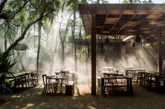 an outdoor dining area with tables and chairs covered in steam