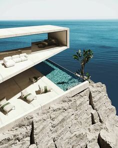 an outdoor swimming pool on top of a cliff next to the ocean