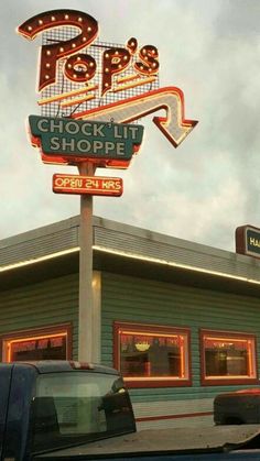 a neon sign that says stop and check out shoppe