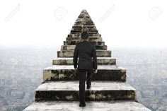 a man in a suit is standing at the top of a stairway with his back to the camera