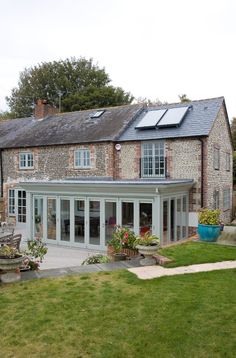 a brick house with large windows and lots of grass