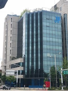 an office building with people walking on the sidewalk