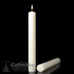 a white candle is lit on a black background