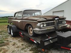 an old truck is being towed by a trailer