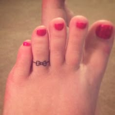 a woman's foot with a bow tattoo on it