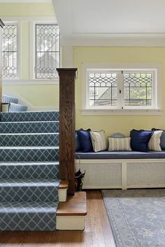 a living room filled with furniture next to a stair case and wooden floored stairs