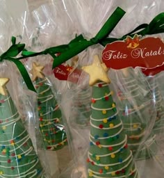 small christmas trees are wrapped in plastic and tied with green ribbon on the top one is labeled feliz naalba