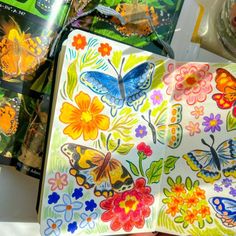 butterflies and flowers are painted on the inside of an open book, with other books in the background