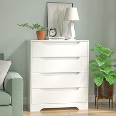 a white dresser sitting next to a green couch