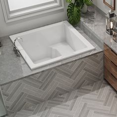 a bath tub sitting next to a window on top of a tiled floor in a bathroom