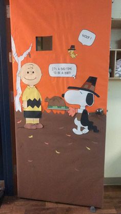 a door decorated to look like peanuts and charlie the pooh with an orange background