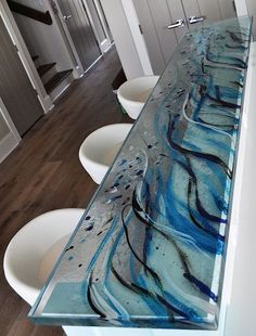 the counter top is made out of glass with blue and black swirls on it