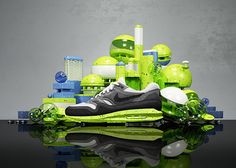 a pair of nike shoes sitting on top of a reflective surface next to green and white objects