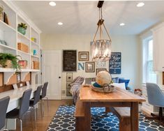 a dining room table with chairs and a light hanging from it's center point