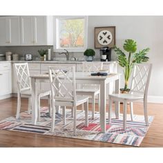 a kitchen table and chairs with a rug on the floor