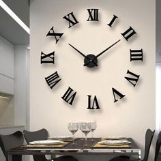 a large clock on the wall above a dining room table with chairs and place settings