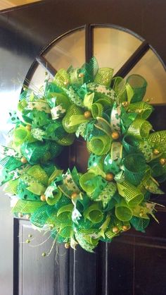 a green wreath is hanging on the front door