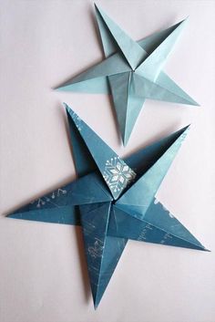 three blue origami stars on a white background