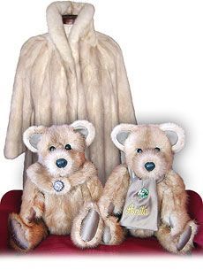 two teddy bears sitting next to each other on a red chair with a fur coat