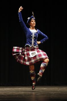 a woman in a kilt dancing on stage