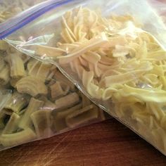 two bags filled with pasta sitting on top of a wooden table