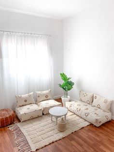 a living room filled with furniture and a rug on top of a hard wood floor