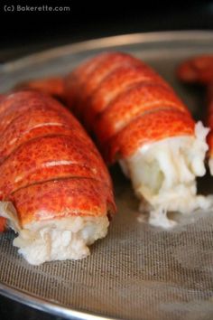 two pieces of sushi sitting on top of a metal pan covered in red sauce