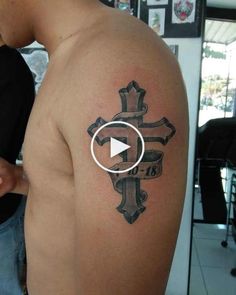 a man with a cross tattoo on his arm