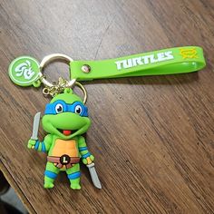 a keychain with a teenage mutant holding a knife on top of a wooden table