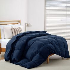 a blue comforter on a bed in a bedroom