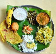 a plate filled with different types of food on top of a green leaf covered table