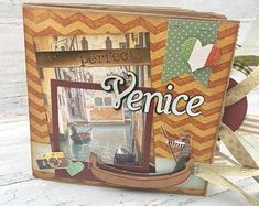 a box that has some pictures inside of it on top of a wooden table with ribbon