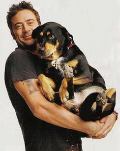 a man holding a dog in his arms