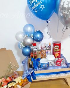 a table topped with blue balloons and lots of food