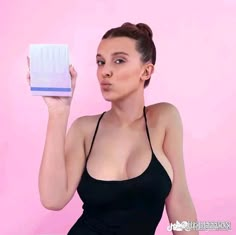 a woman is holding up a box in front of her face