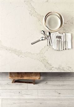 silverware and utensils are arranged on a marble countertop