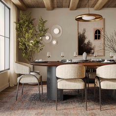 a dining room table with four chairs and a potted plant in the center, on top of an area rug