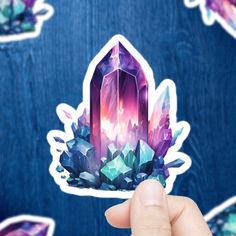 a hand holding up a sticker with crystals on it