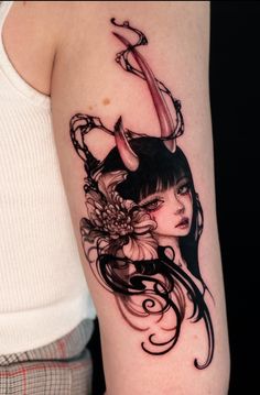 a woman with horns and flowers on her arm